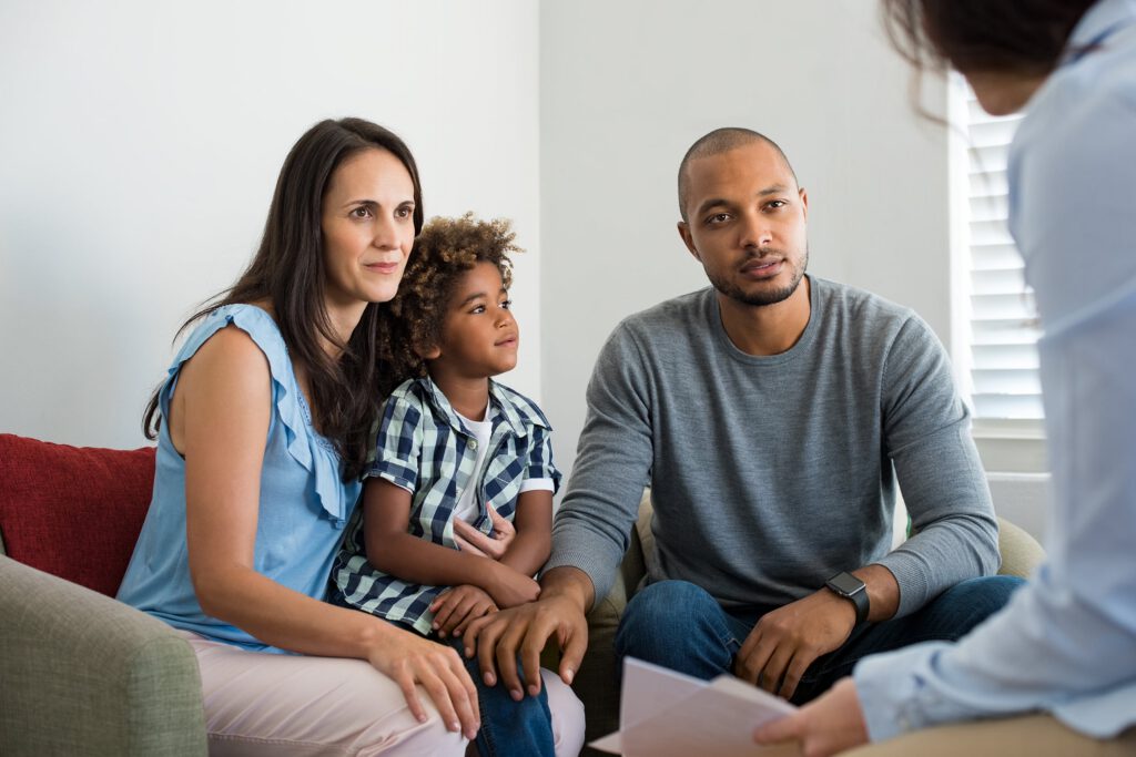 Family with young child attending a behavioral health counseling session with therapist