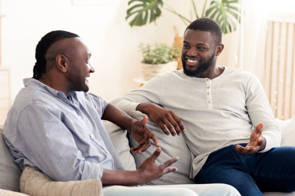 Father and adult son having a supportive conversation about mental health at home