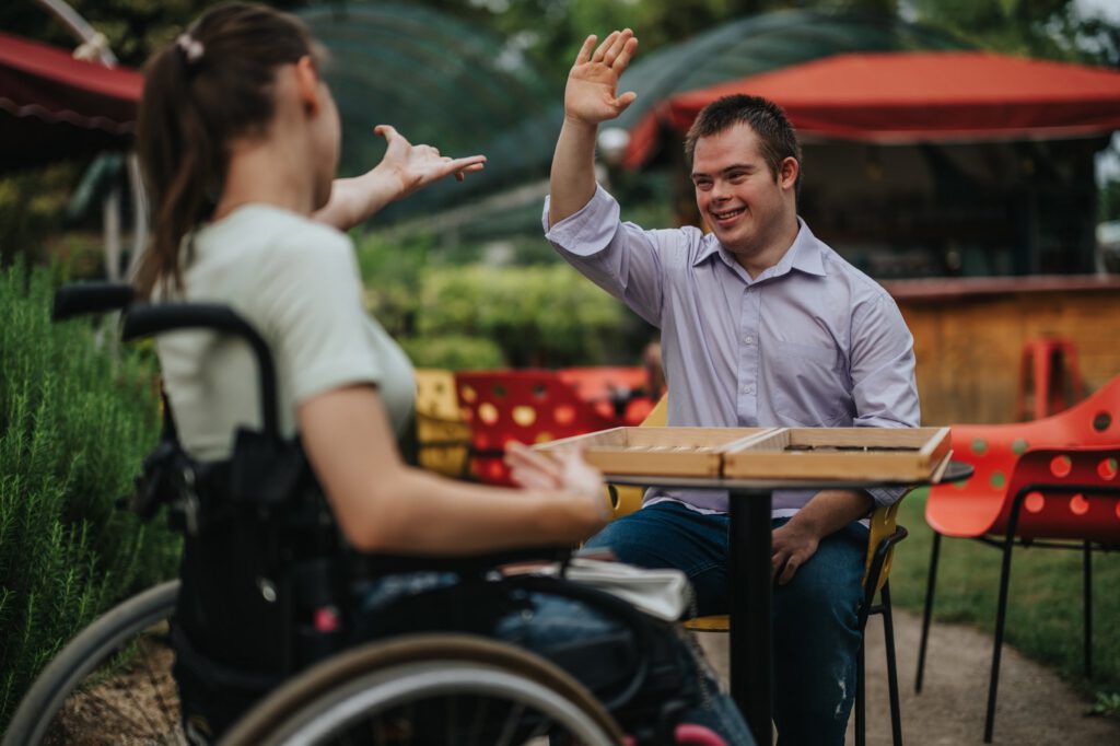 Friends sharing a high five in inclusive community setting
