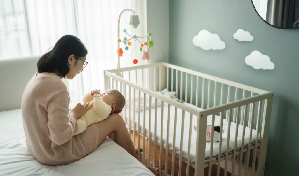 Mother holding a newborn baby in a calm nursery setting