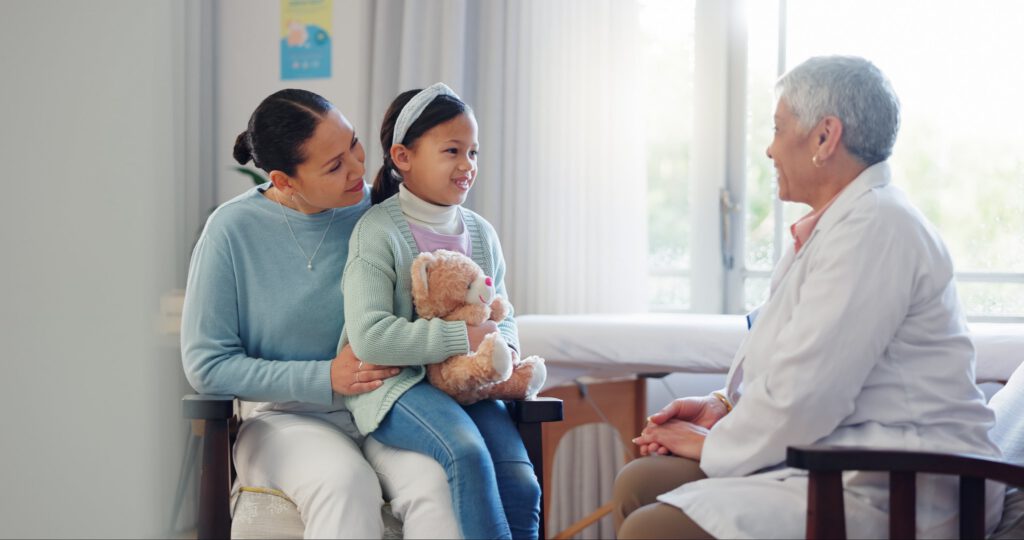 Doctor talking with parent and child during pediatric appointment