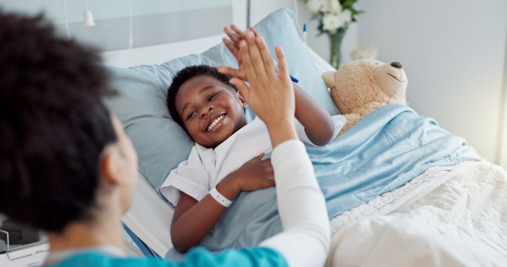Child high-fiving clinician during hospital care