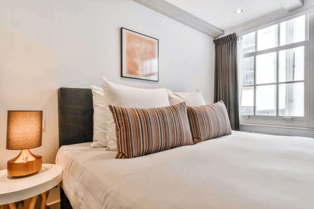 Bright, tidy bedroom with a made bed and large window