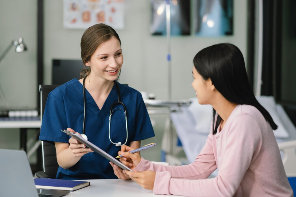 Nurse practitioner discussing treatment options and explaining a care plan to a patient in a clinical setting