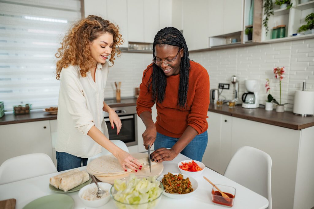 Two women cooking together during a therapeutic life skills group activity